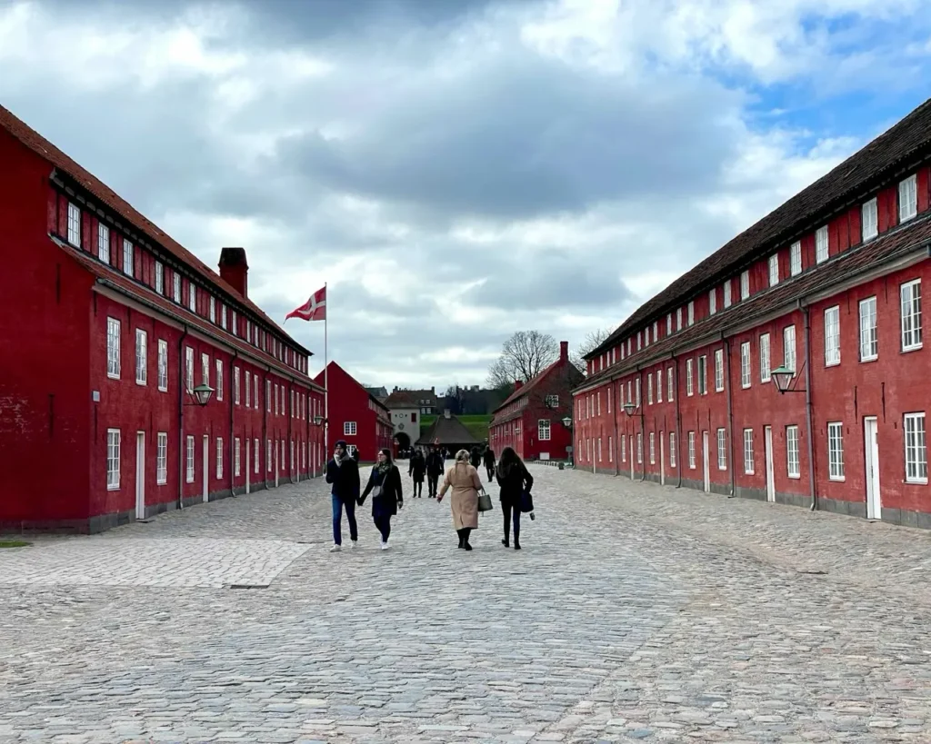 People walking through the red buildings of Kastellet fortress