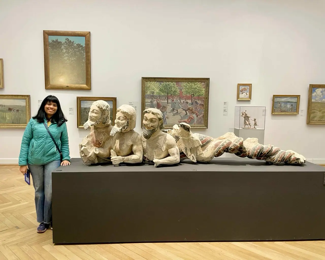 Agalya standing beside the sculptures displayed at the SMK museum